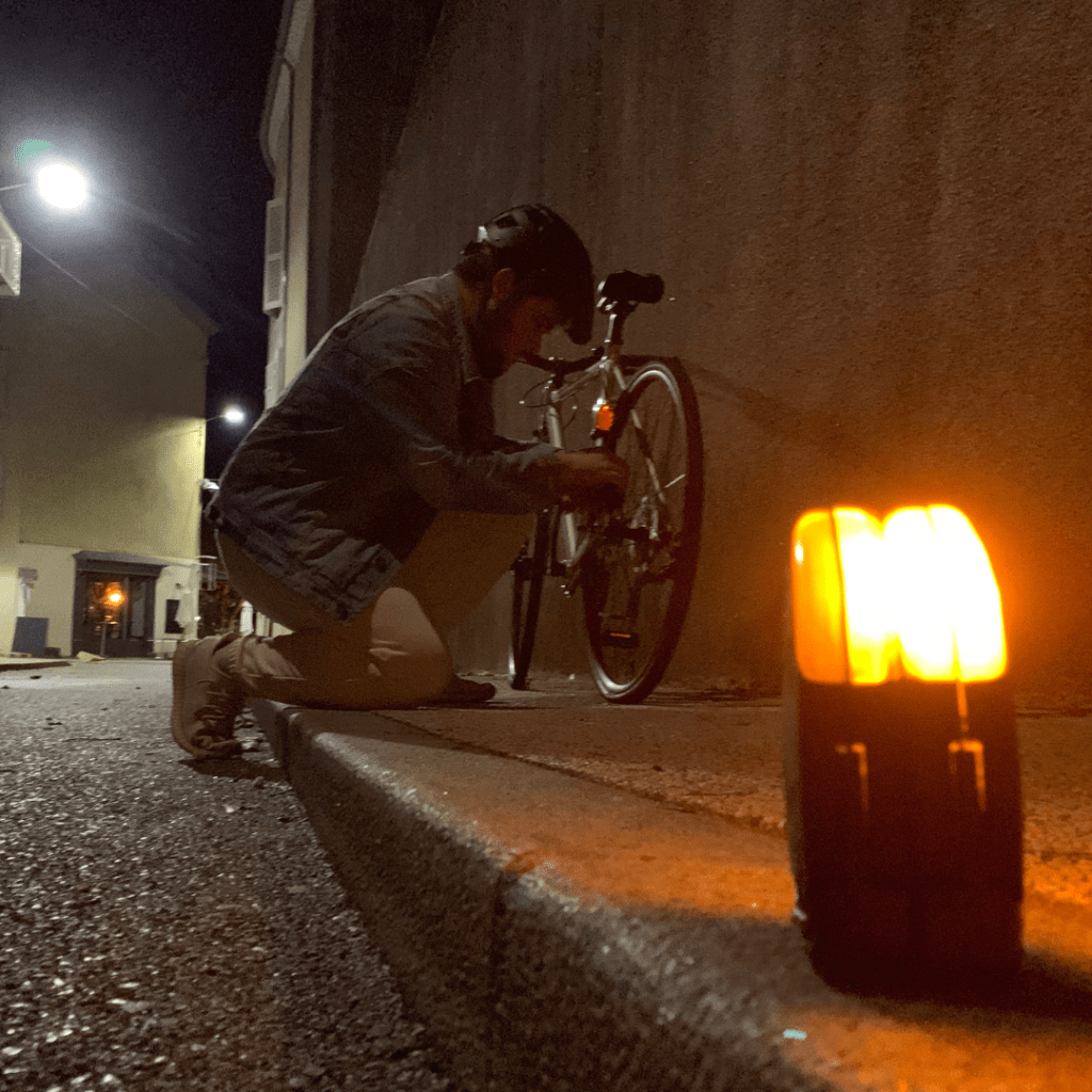 Photo de mise en situation où on aurait crevé son pneu. Le temps de le réparer, vous pouvez utiliser vos QLÏR comme triangle de signalisation afin d'informer les différents usagers de la route.